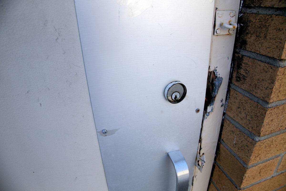 A Commercial Entry Door with Damage Around the Lock Caused by a Break-In Attempt in Edmonton, AB