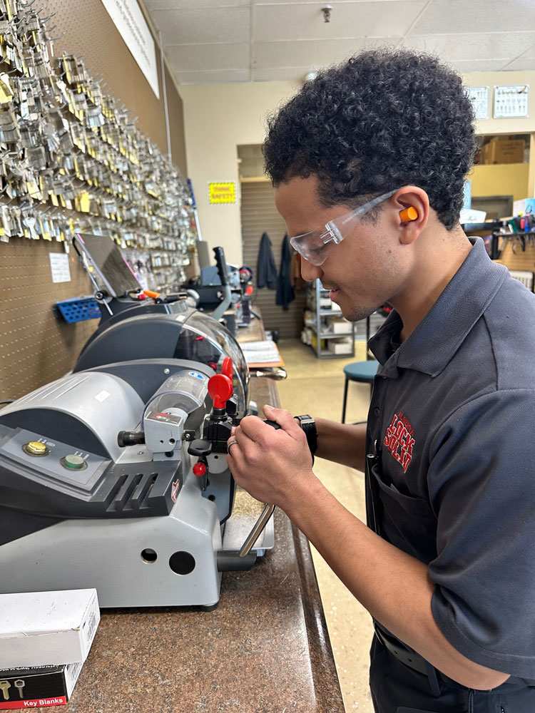 An Automotive Locksmith Is Creating a Replacement Car Key with a Key-Cutting Machine in Edmonton, AB